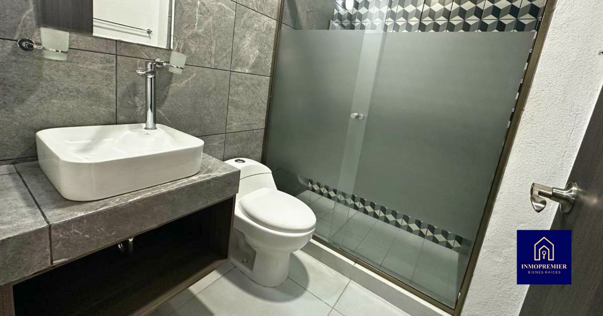 Baño completo de departamento en venta en Altozano Morelia Quinta Cantera con cancel de vidrio y acabados modernos