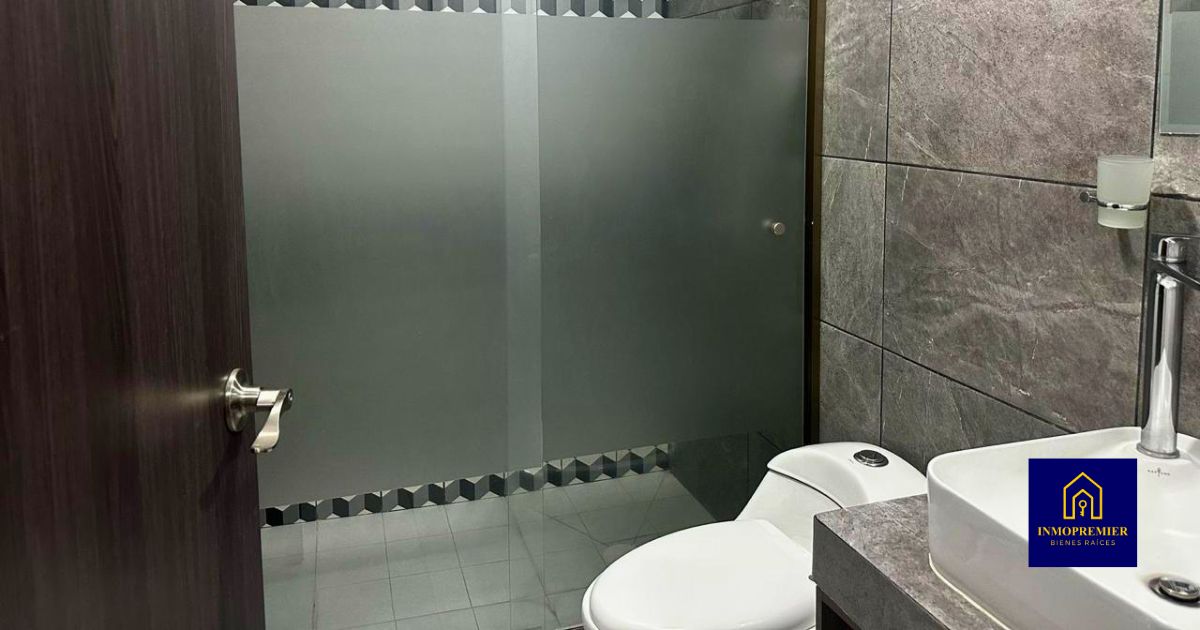 Baño secundario de departamento en venta en Altozano Morelia Quinta Cantera con cancel de vidrio y acabados modernos