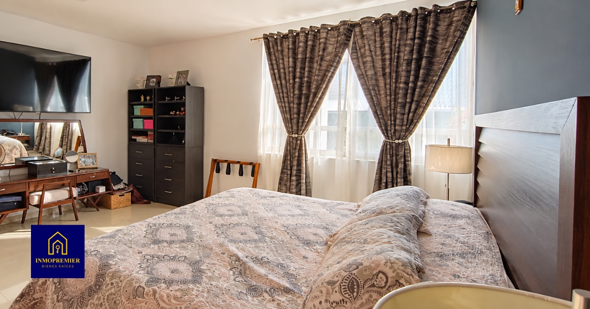Recámara amplia con cama, cortinas y tocador en Golondrinas